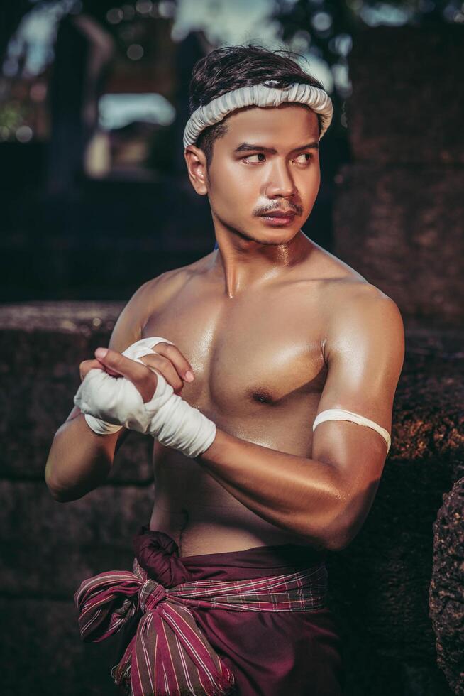 Der Boxer setzte sich auf den Stein, band sich das Klebeband um die Hand und bereitete sich auf den Kampf vor. foto