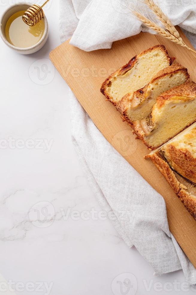 Draufsicht auf geschnittenes Bananenbrot auf hellem Betonhintergrund foto