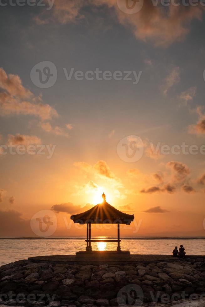 Sonnenschein über Pavillon am Steg an der Küste am Morgen foto