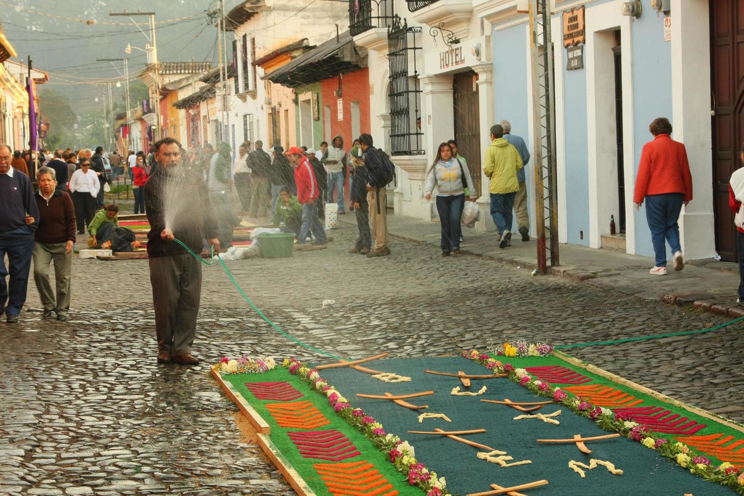 Antigua, Guatemala, 10. April 2009 - Mann, der bunte Alfombras-Teppiche gießt? foto