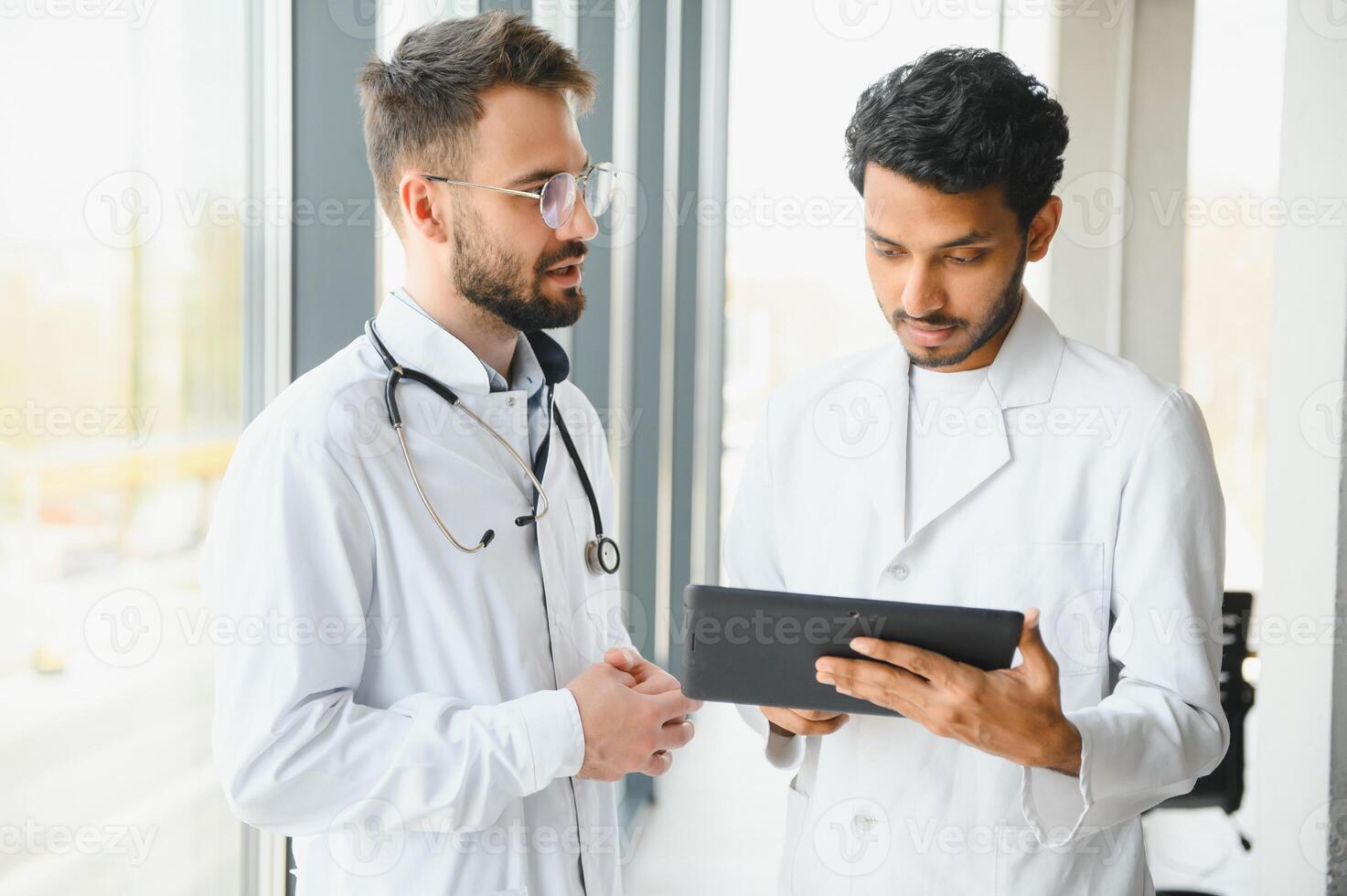 ein indisch Arzt und ein europäisch Arzt Stand zusammen im ein Krankenhaus Empfangshalle foto