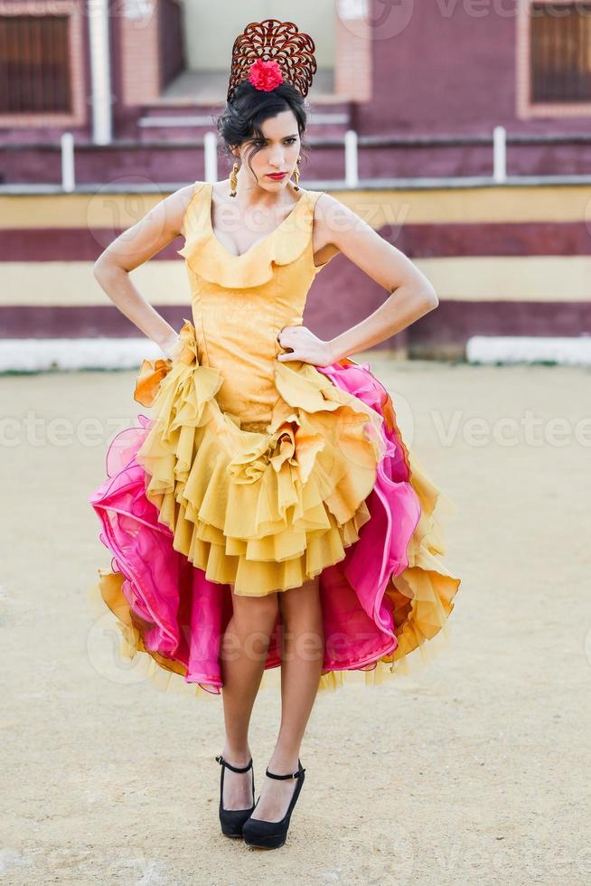 Frau, Model der Mode, trägt ein Kleid in einer Stierkampfarena foto