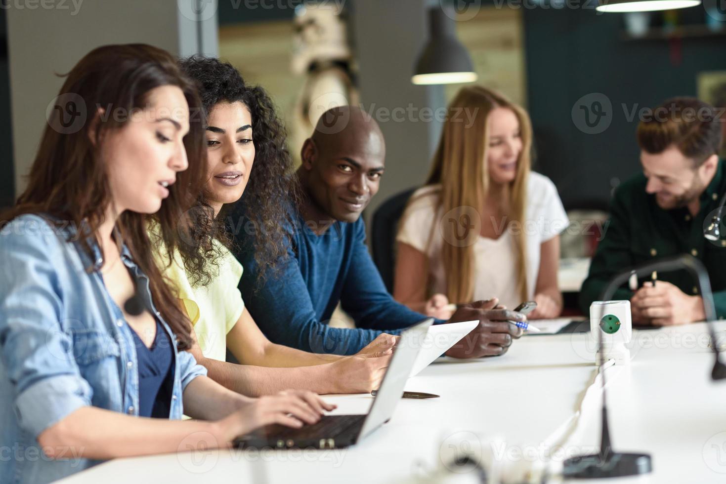 multiethnische Gruppe junger Leute, die mit Laptop studieren foto