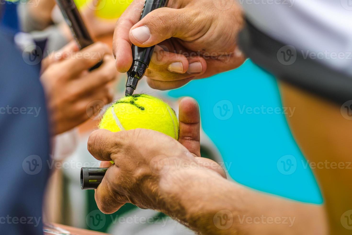 Tennisspieler gibt nach dem Sieg ein Autogramm foto