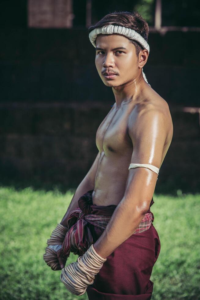 Thai-Boxer wickeln das Band in die Hände und stellen sich auf den Rasen. foto