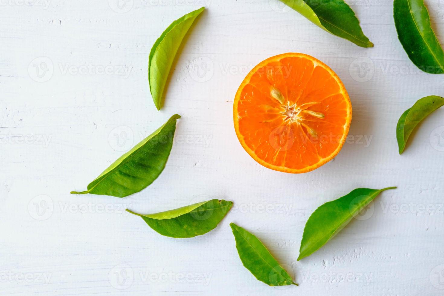 frische Orangenfrucht halbiert auf weißem Holzhintergrund foto