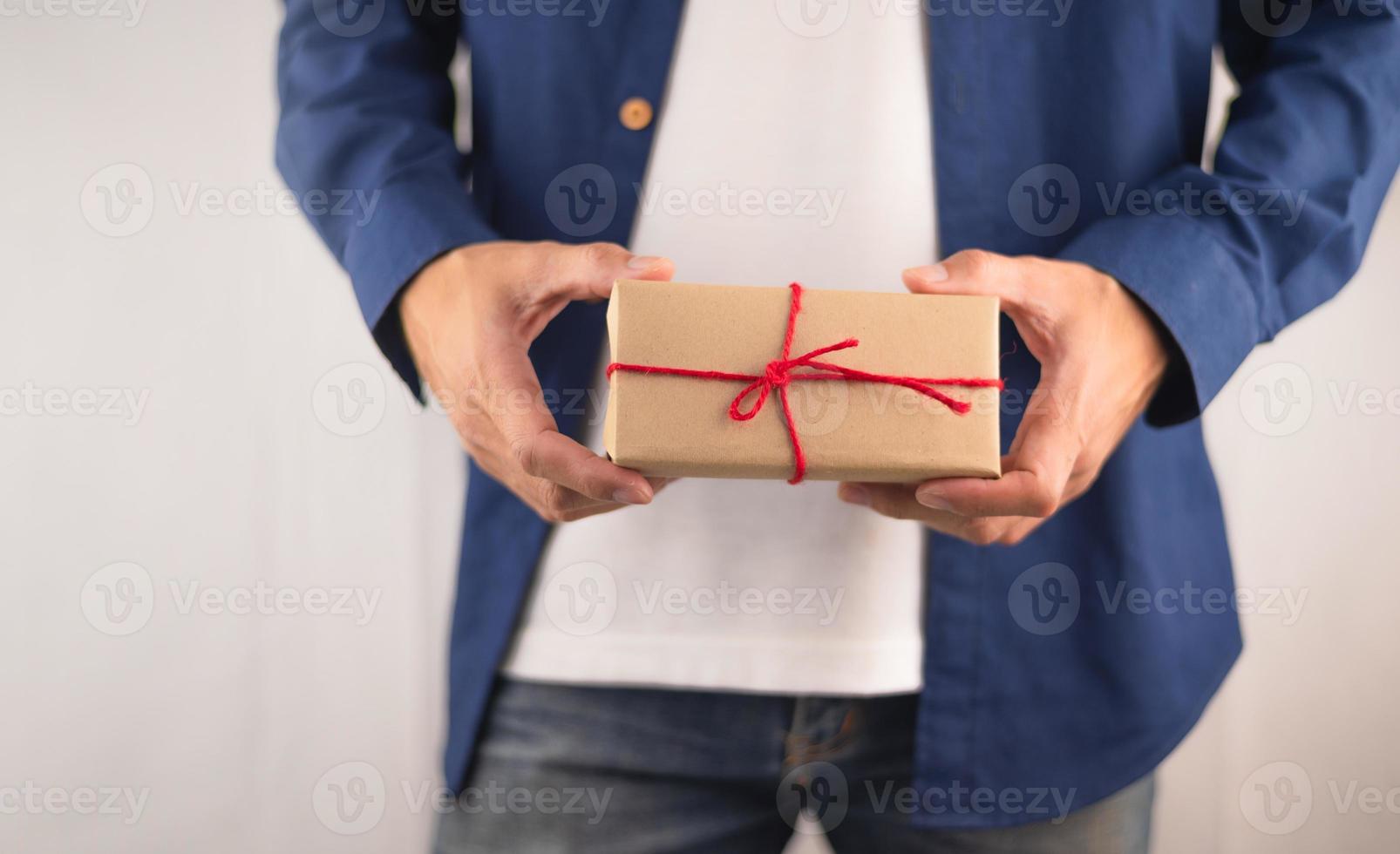 Nahaufnahmehand, die Geschenkbox, Geschenkbox des neuen Jahres, Weihnachtsgeschenkbox, Kopienraum hält. Weihnachten, Jahr, Geburtstagskonzept. foto