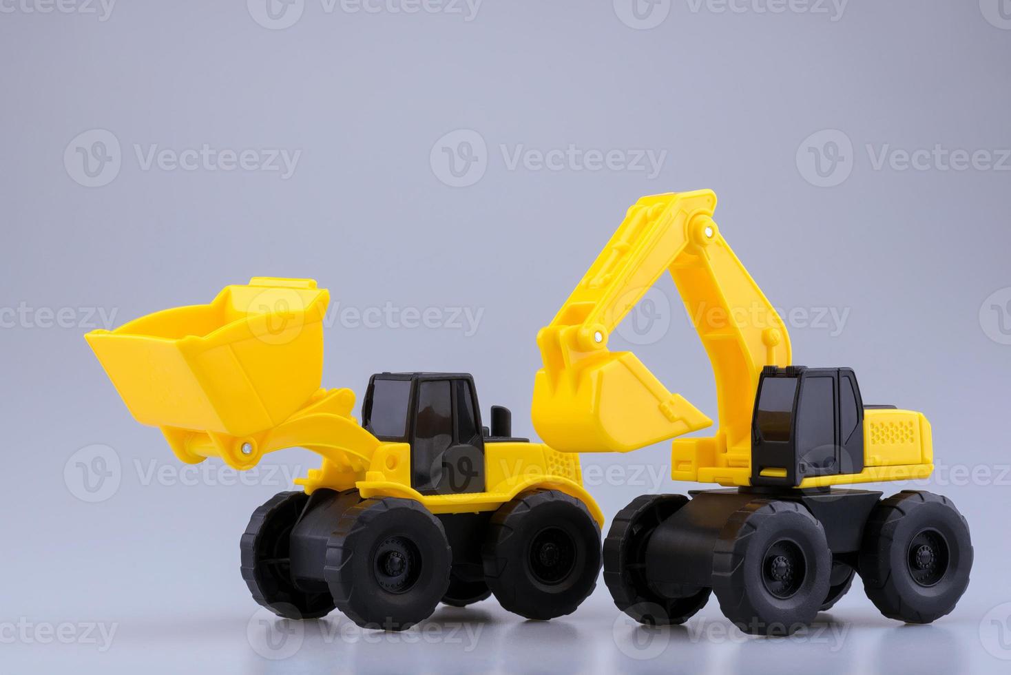 Heavy Duty Bagger und Traktor Spielzeug auf klarem Hintergrund. foto
