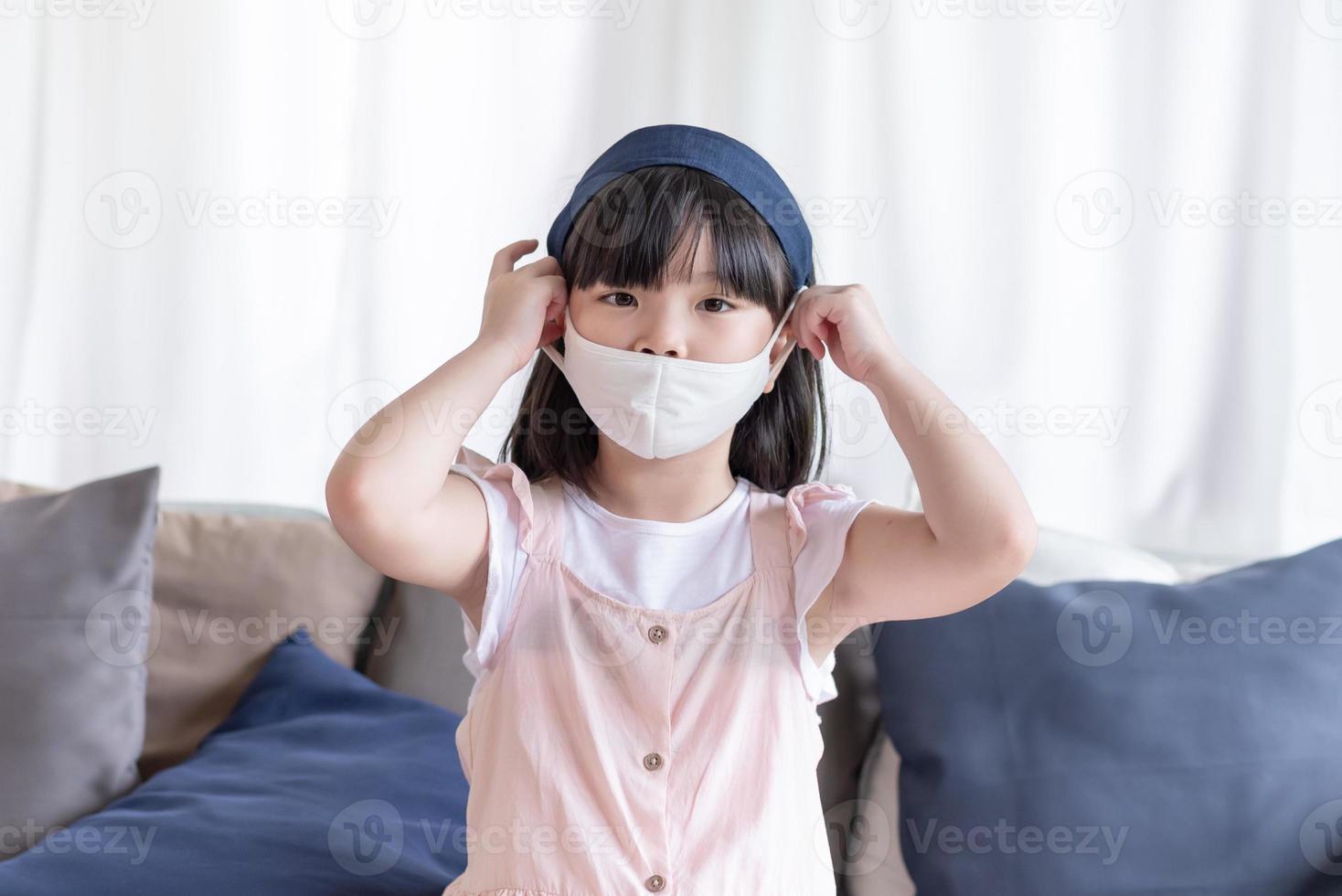 Asiatisches süßes Mädchen mit hygienischer Gesichtsmaske zur Vorbeugung von Coronavirus oder Covid19 foto