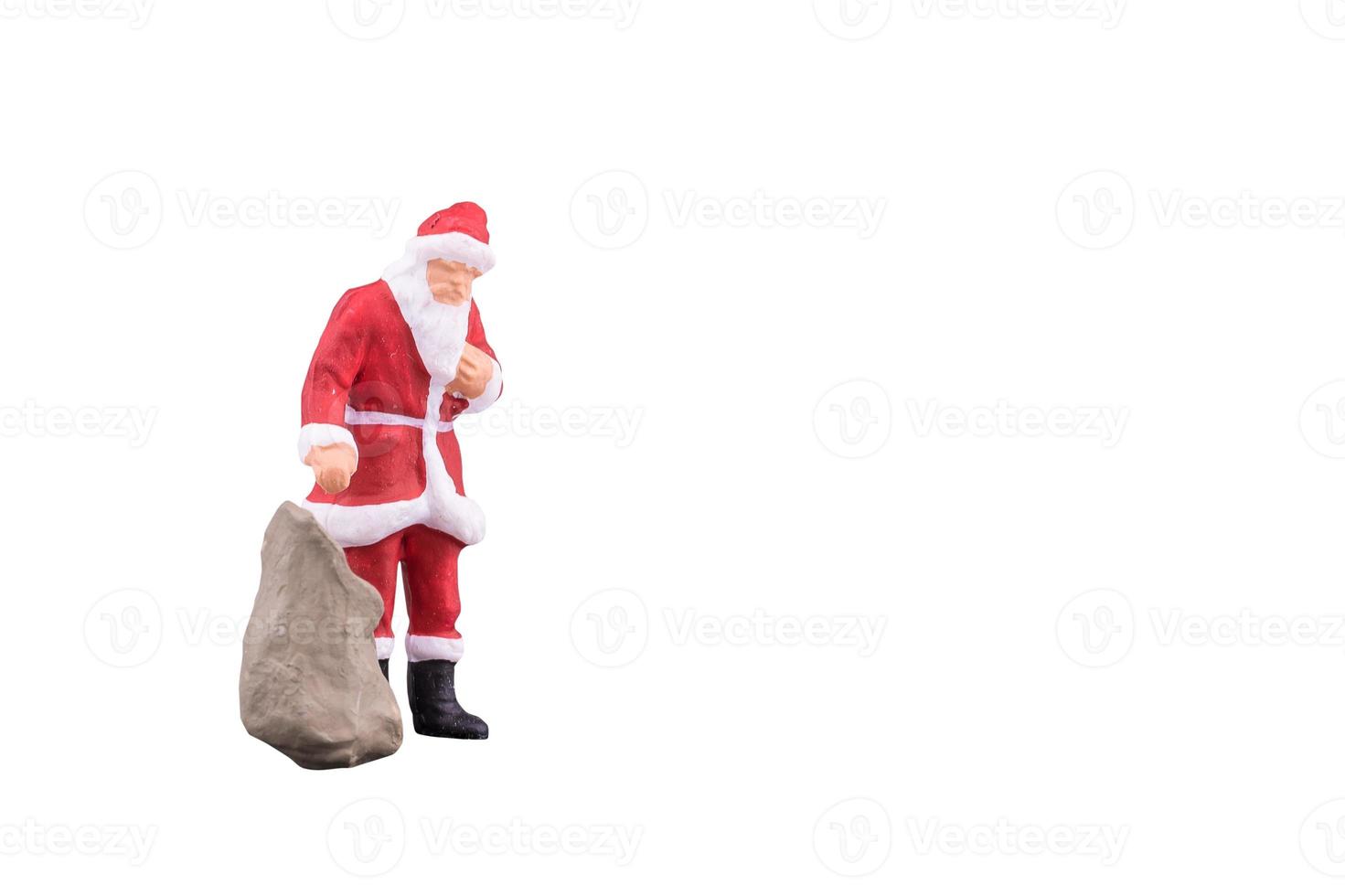 Nahaufnahme von Miniatur-Weihnachtsmann und Geschenktüte isoliert mit Beschneidungspfad auf weißem Hintergrund. Elegantes Design mit Kopienraum für die Platzierung Ihres Textes, Mock-up. foto