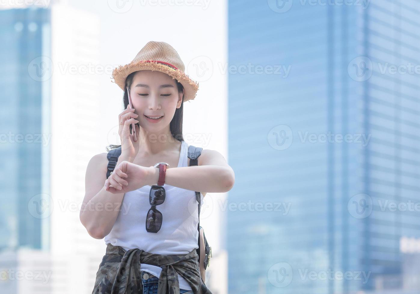 Schöne asiatische Solo-Touristenfrau, die lächelt und genießt, über das Handy in der Innenstadt zu sprechen. Urlaubsreisen im Sommer. foto