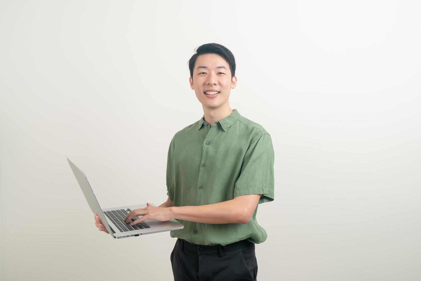 junger asiatischer Mann mit Laptop zur Hand foto