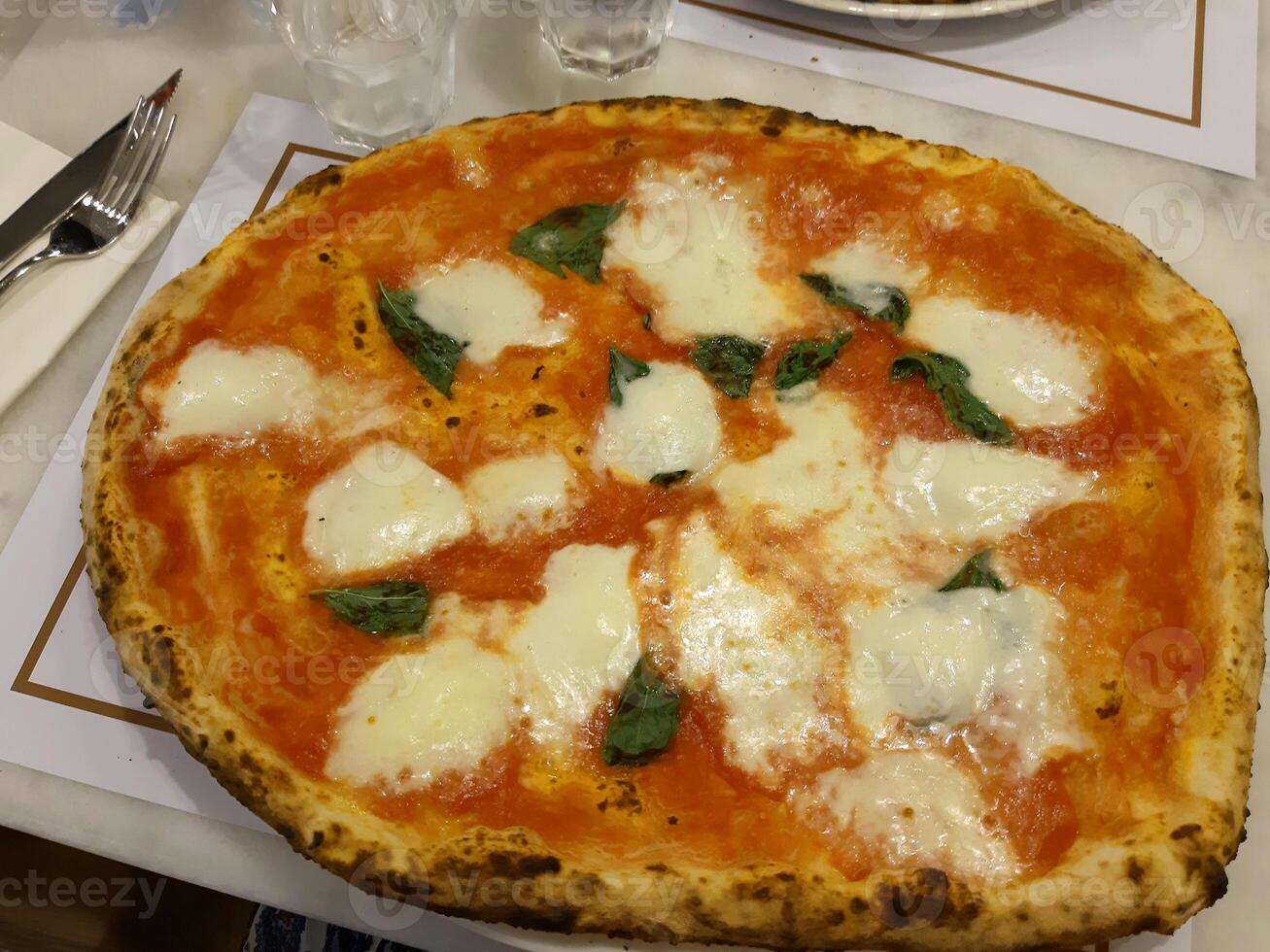 Pizza leckere heiße Peperoni bedeckte Scheiben kochen Zutaten Tomaten mit Schinken und roten Tomatengewürzen auf dem Tisch. foto