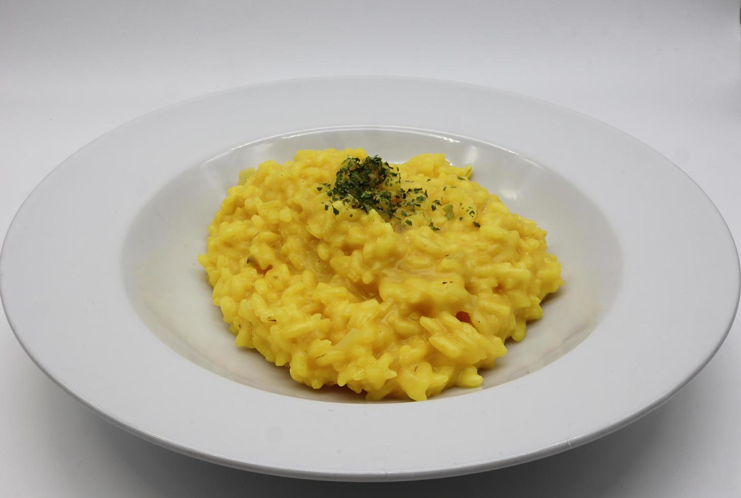 italienisches Risotto allo Zafferano, Reis mit Safran, in einer weißen Schale foto