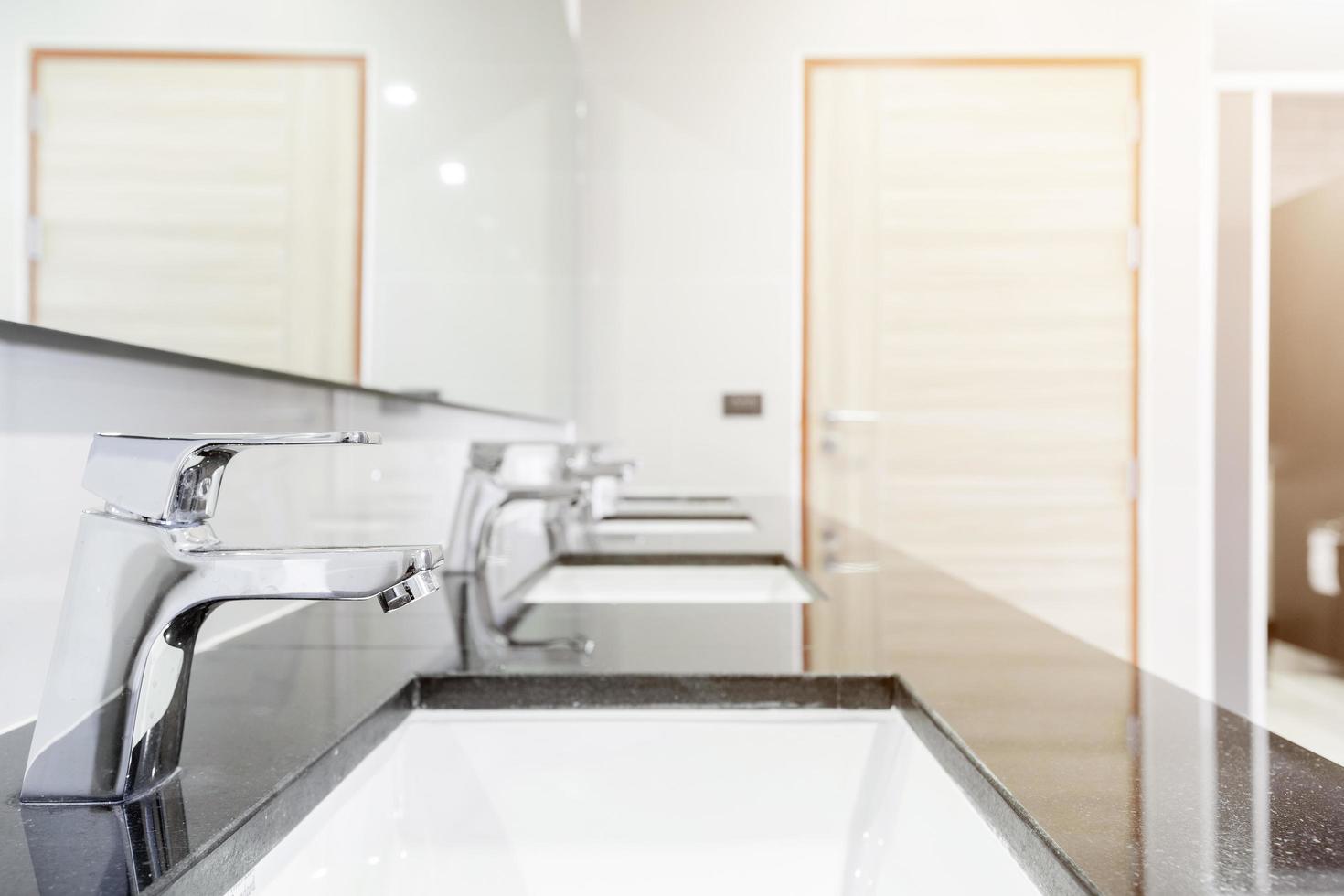 Öffentlicher Innenraum des Badezimmers mit Waschbecken Wasserhahn aufgereiht modernes Design. foto