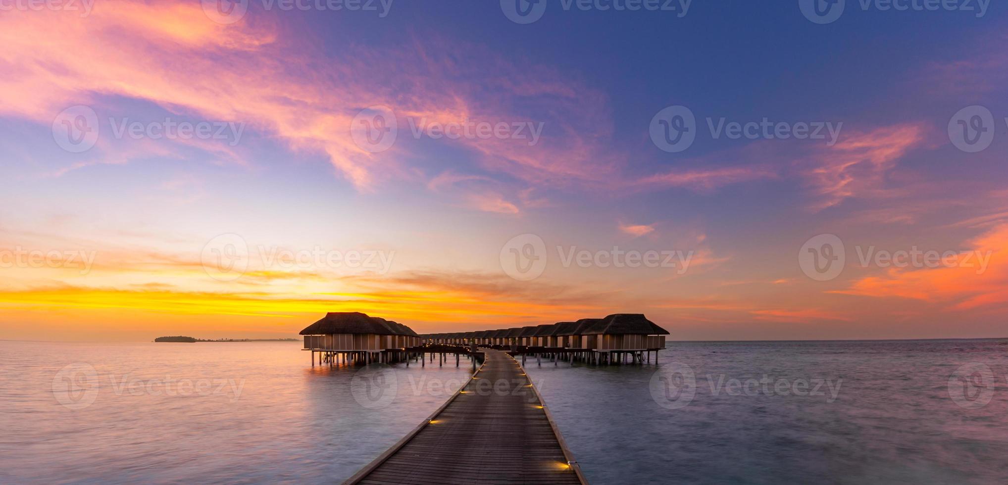 Erstaunliches Sonnenuntergangspanorama auf den Malediven. Luxusresortvillen mit weichen LED-Leuchten unter buntem Himmel. schöner Dämmerungshimmel und bunte Wolken. schöner Strandhintergrund für Ferienurlaub foto