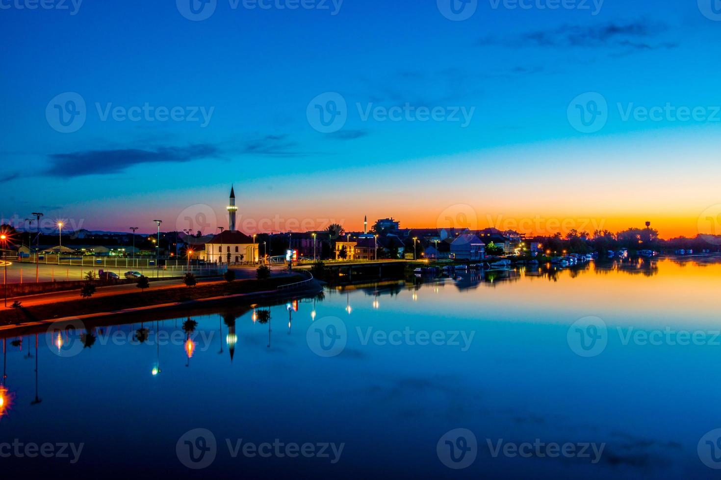 Sonnenuntergang über Fluss und Stadt foto