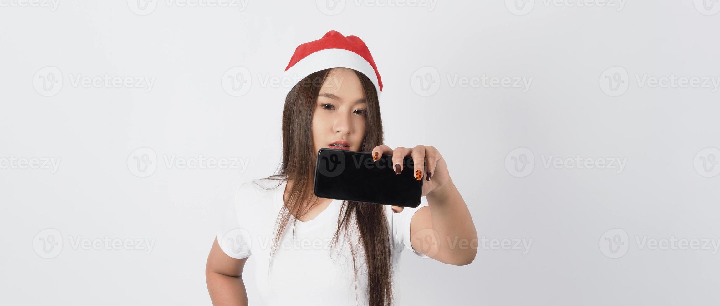 asiatische Frau mit Smartphone in der Hand, die wie Selfie oder Videoanruf posiert foto