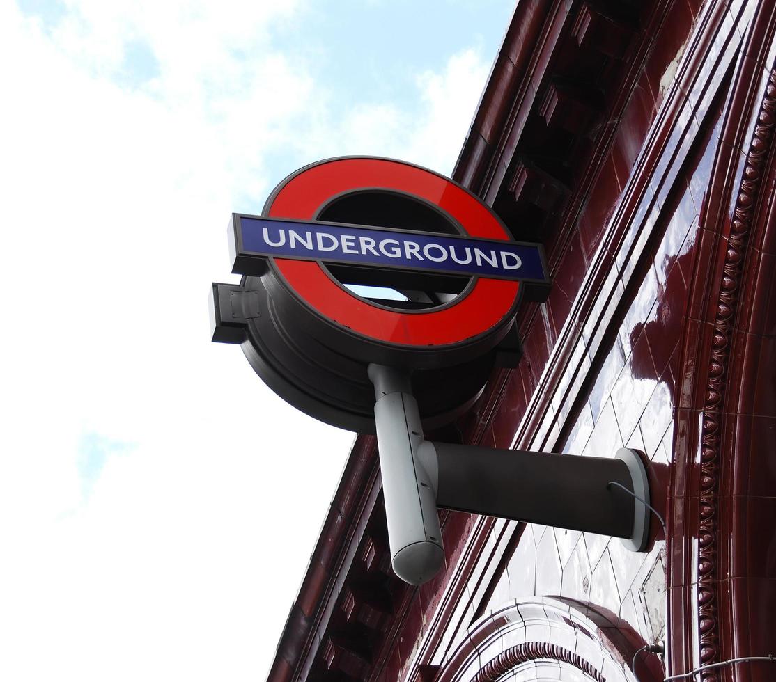 London, Vereinigtes Königreich, 2014 - U-Bahn-Schild hängt von einem Gebäude von London. Londoner U-Bahn-Schild foto