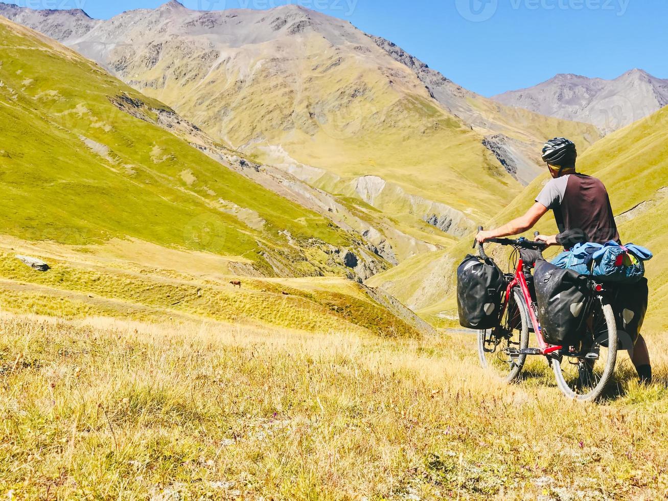 Rückansicht Radfahrer schieben Tourenrad bergauf zum Berg. Atsunta-Pass-Trekkingroute mit dem Fahrrad foto