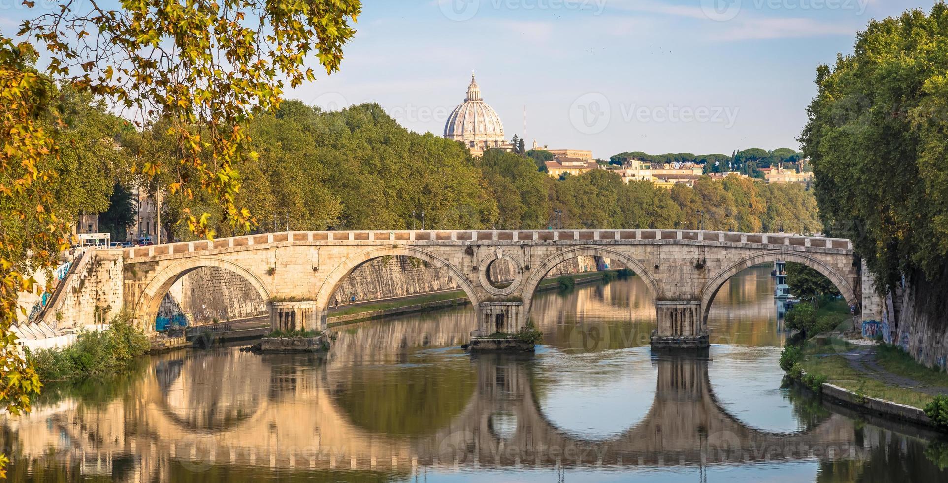 Brücke am Fluss Tiber in Rom, Italien. Vatikan-Basilika-Kuppel im Hintergrund mit Sonnenaufganglicht. foto
