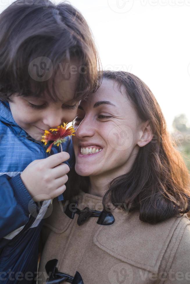 ein Kind schenkt seiner Mutter eine Blume foto