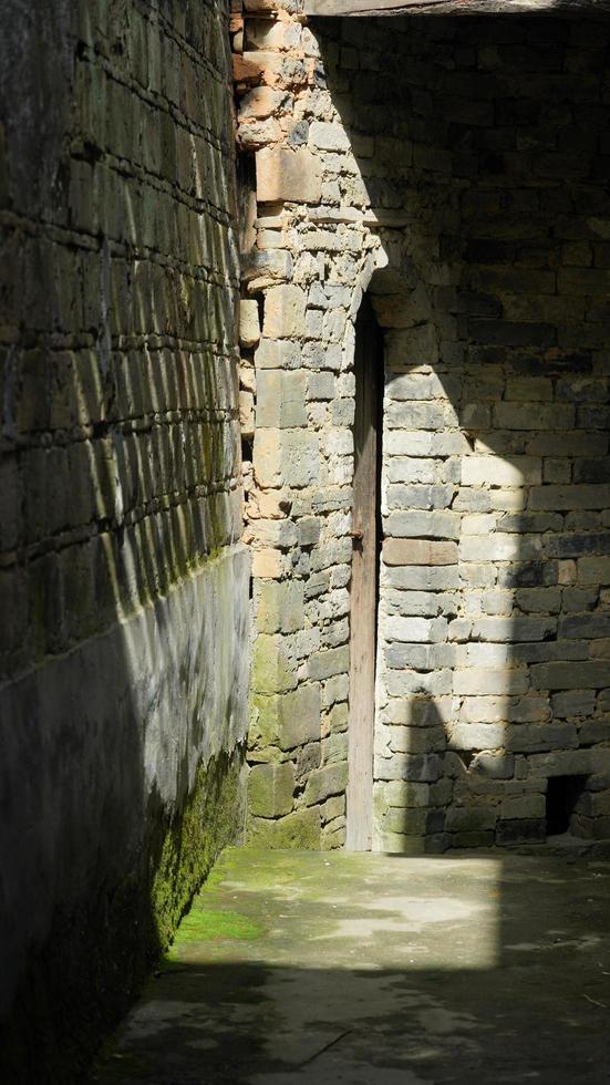 die alte chinesische dorfansicht mit sonnenlicht und schatten auf der backsteinmauer foto