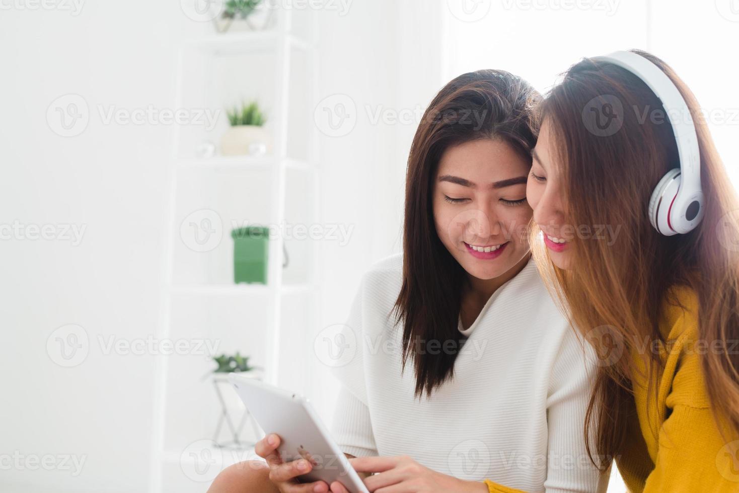 Asiatisches junges lesbisches Paar, das in einem glücklichen Moment der Liebe im Schlafzimmer zusammen Musik hört. LGBT-Paar, das Musik in einem Liebesgefühl hört. LGBT-Liebespaar im Schlafzimmerkonzept. foto