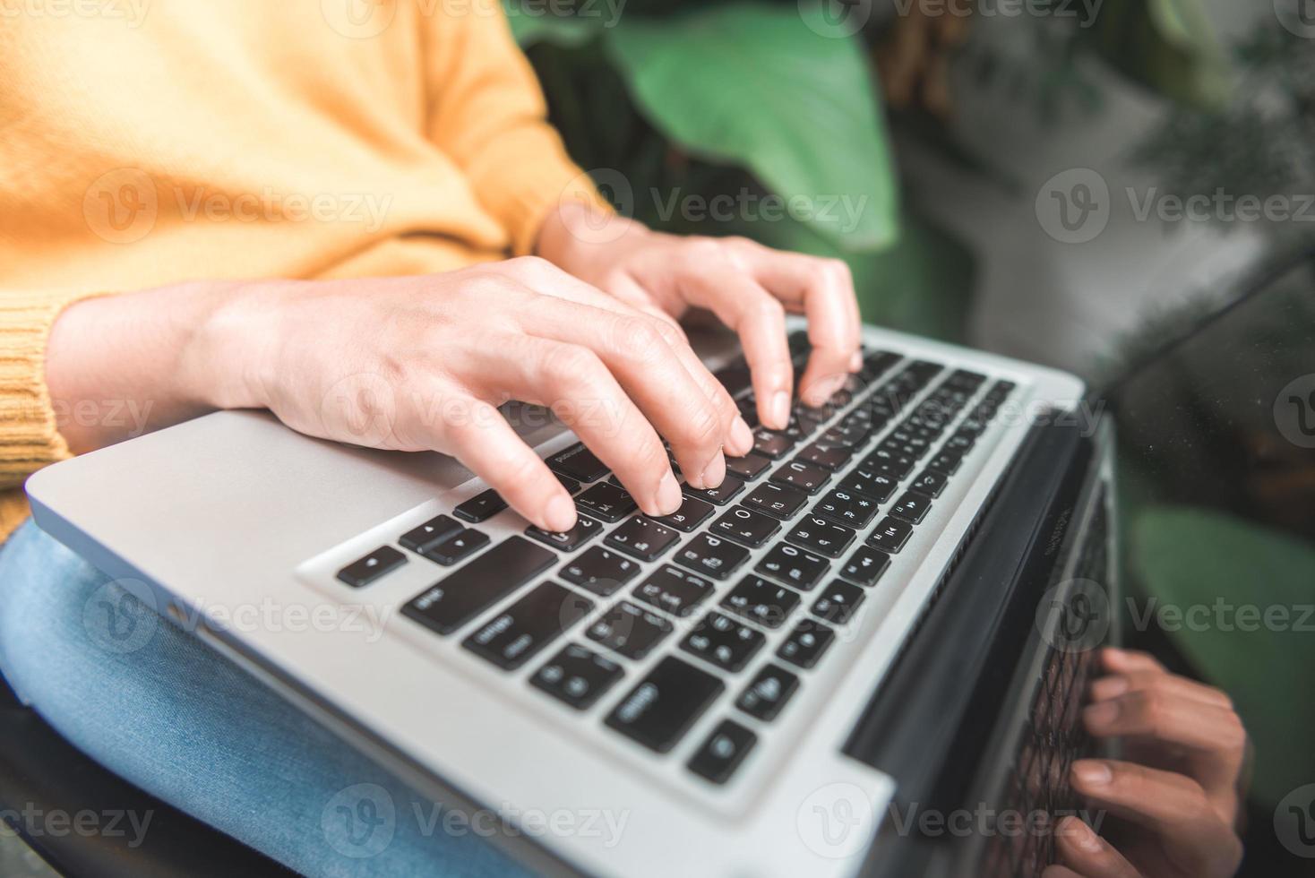 Nahaufnahme der jungen Frau, die mit ihrem Laptop in einem Café-Garten mit dem Hintergrund eines grünen Baumes online einkaufen. junge Frau, die online Waren im Garten einkauft. Online-Shopping-Konzept. foto