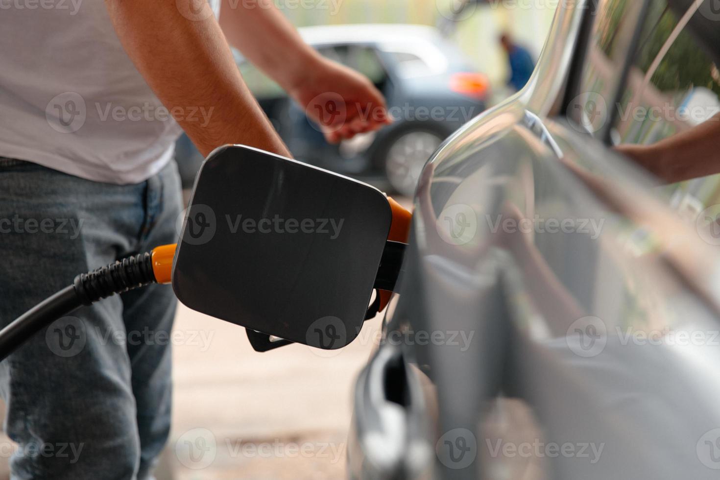 Hand-Mann-Nachfüllen und Füllen von Öl-Gas-Kraftstoff an der Station. foto