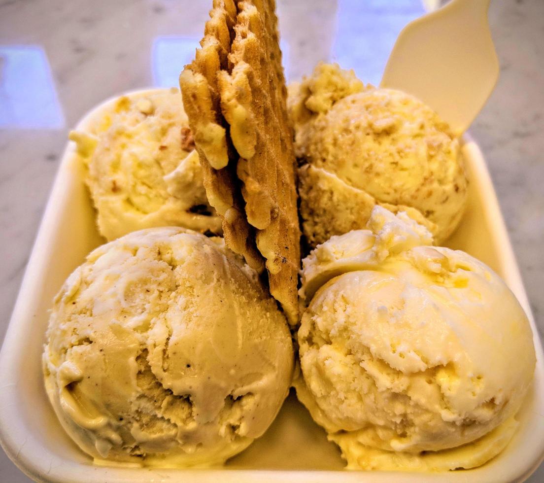 Eiscreme-Geschmack gefrorenes Dessertmuster in der weißen Tasse Hand, die auf dem Tisch hält. foto