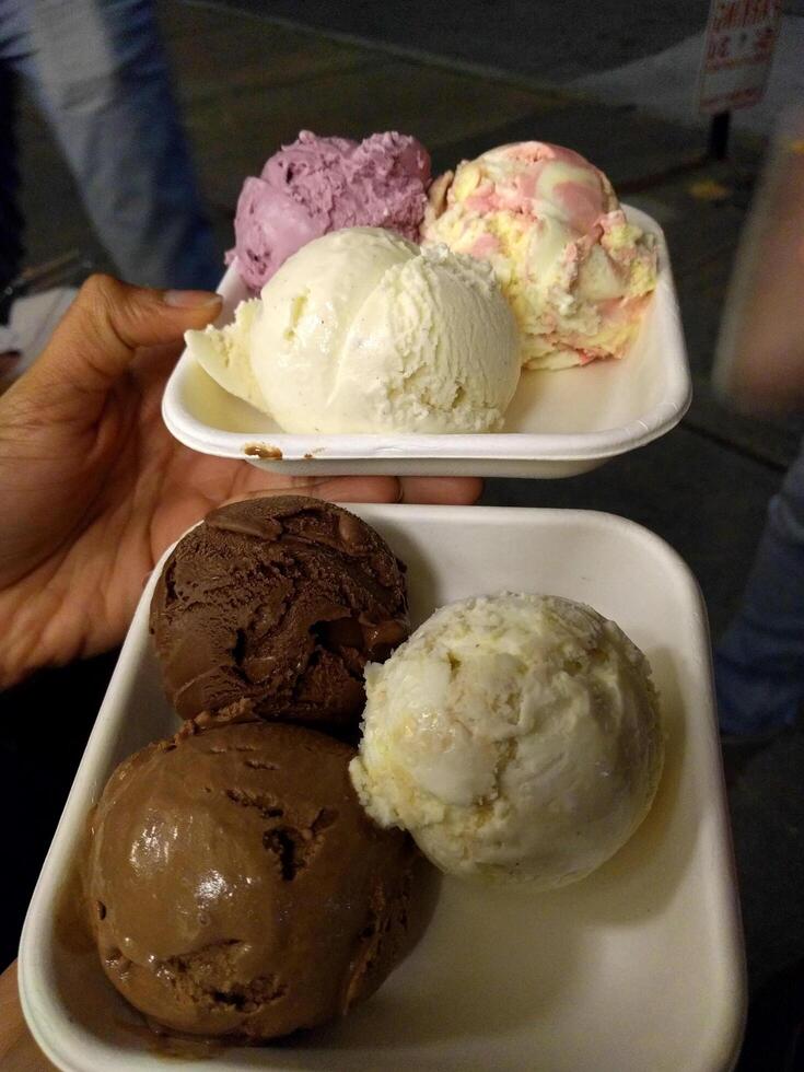 Eiscreme-Geschmack gefrorenes Dessertmuster in der weißen Tasse Hand, die auf dem Tisch hält. foto