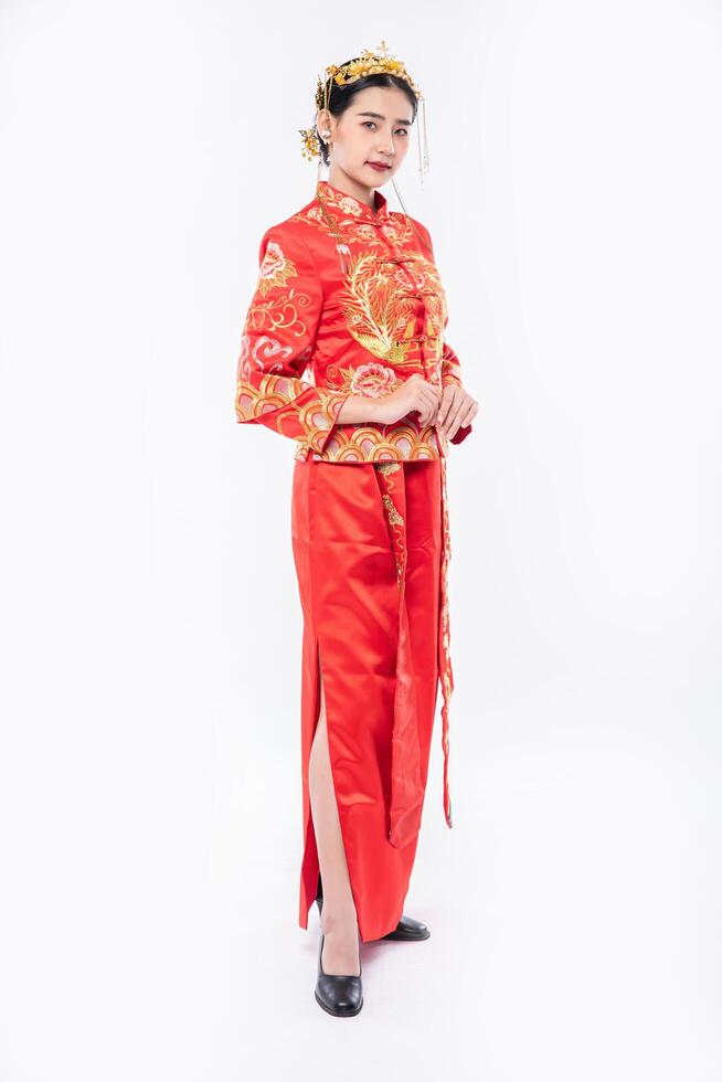 Frau trägt Cheongsam-Anzug, um Reisende beim Einkaufen im chinesischen Neujahr willkommen zu heißen foto