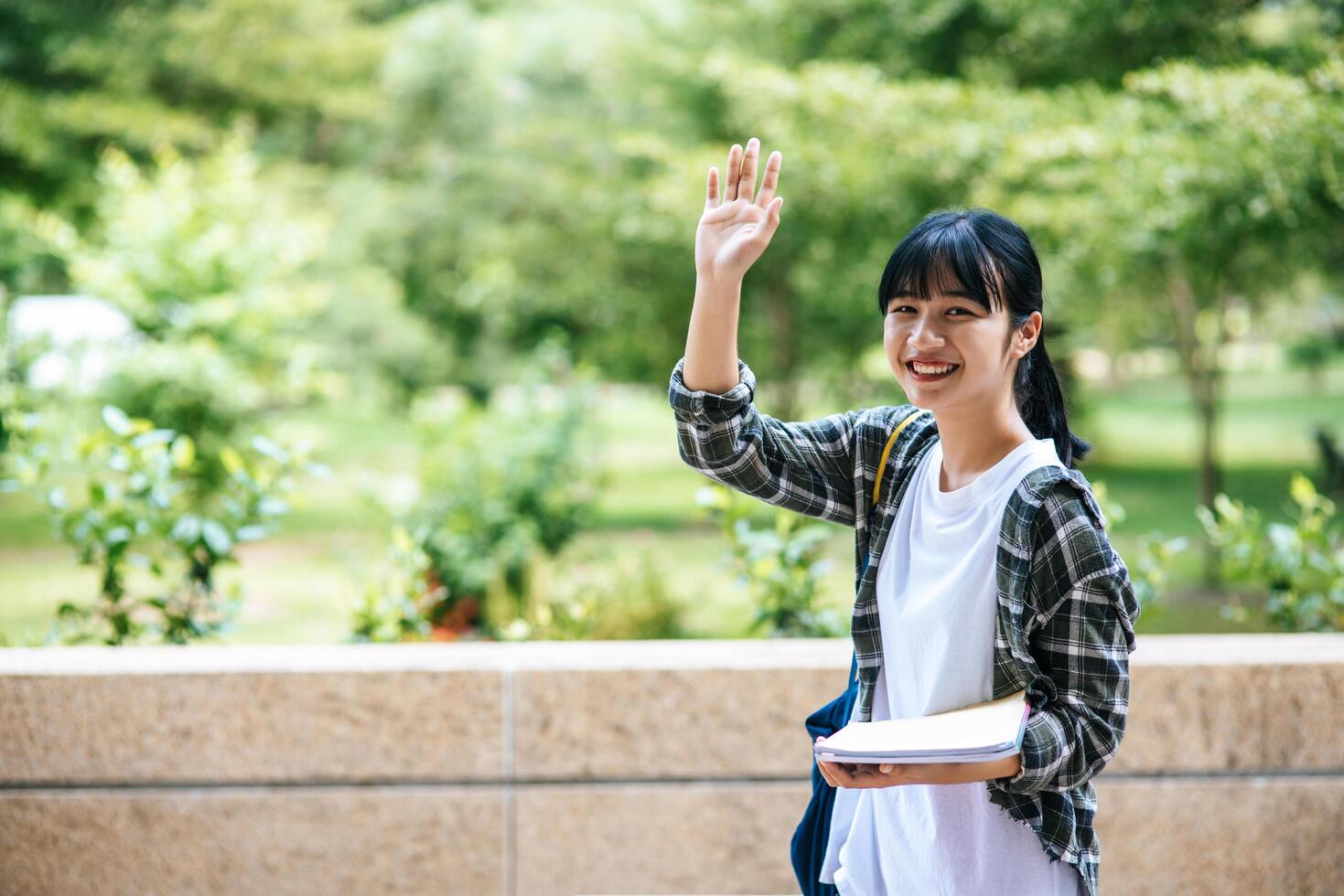 Studentinnen stehen auf der Treppe und halten Bücher in der Hand. foto