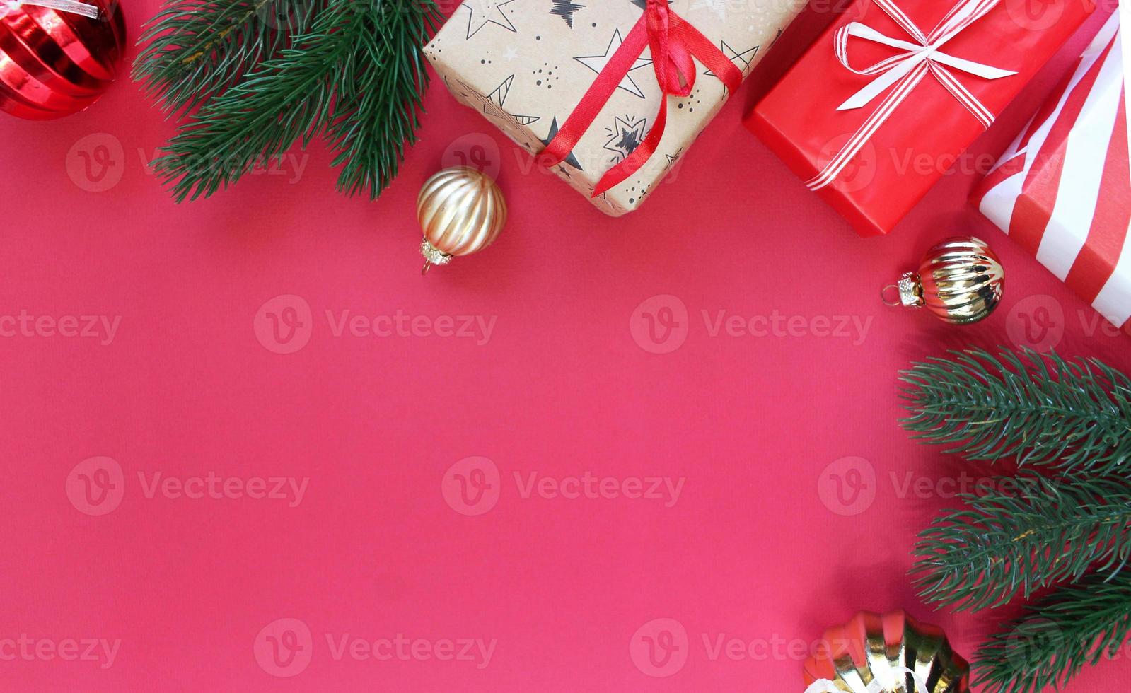 Weihnachtskomposition. Boxen als Geschenk auf Ast Tanne auf rotem Hintergrund. Ansicht von oben, Textfreiraum foto