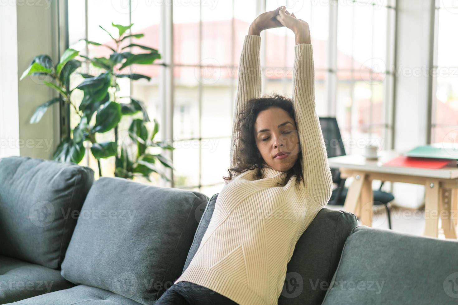 lateinische frau auf sofa mit faulheitsgefühl foto