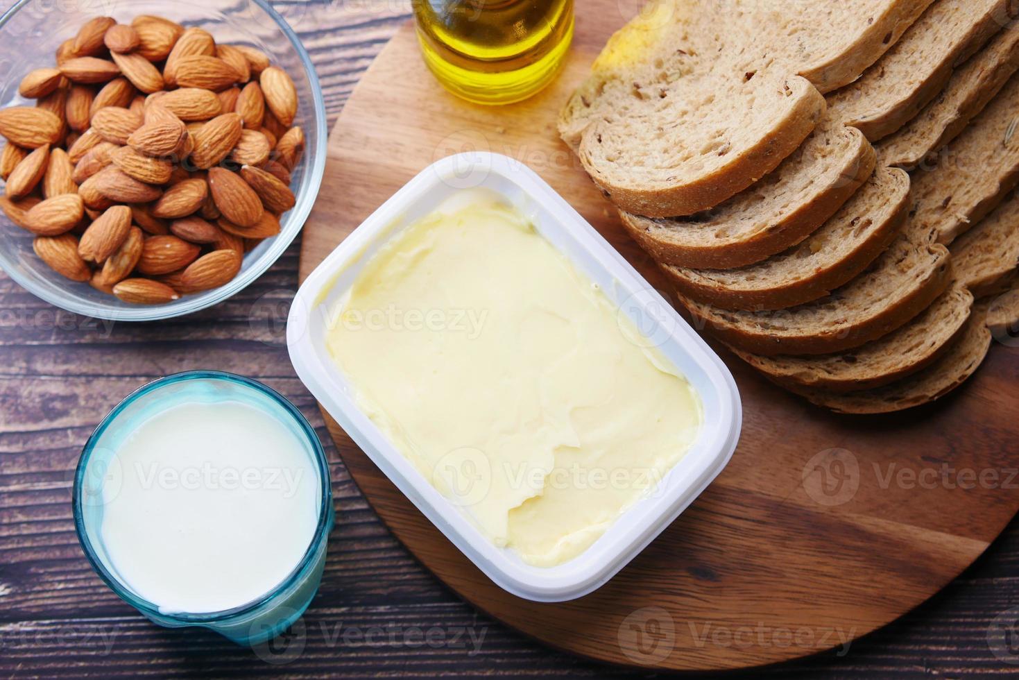 Butter, Milch, Brot und Mandeln auf dem Tisch foto