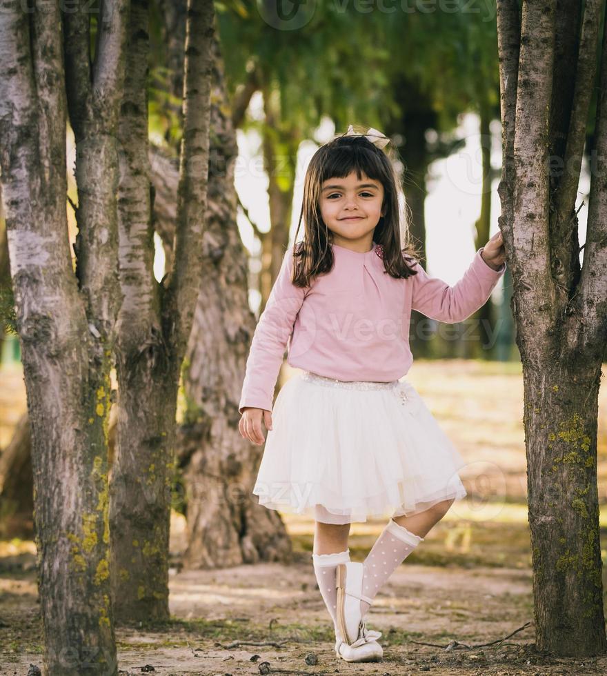 kleines Mädchen posiert in einem Park foto