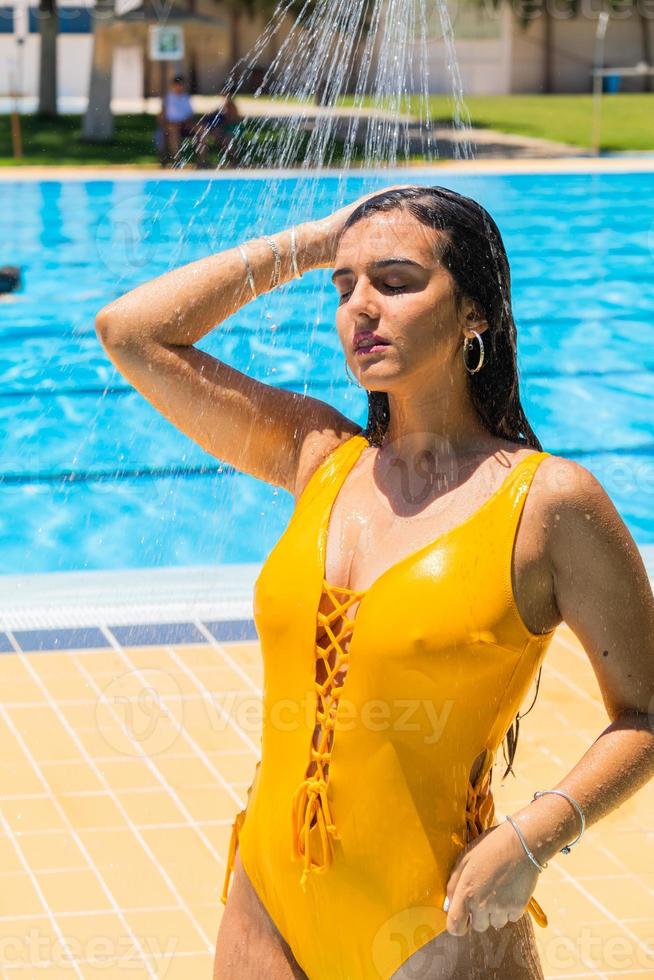 junge Frau duscht vor dem Baden im Pool foto