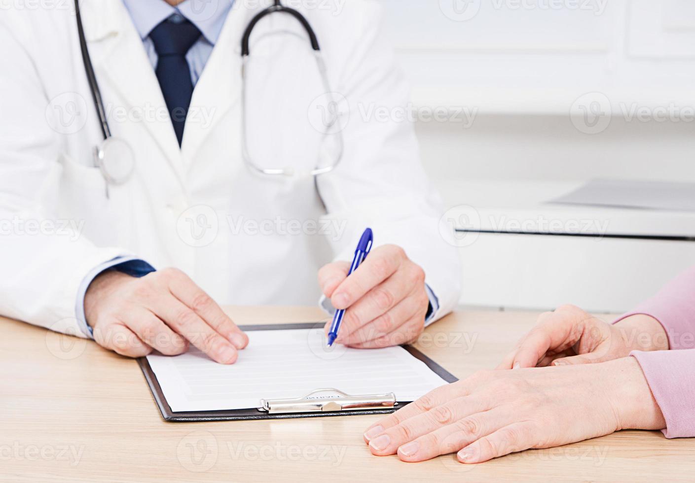 Arzt und Patient diskutieren etwas, nur Hände am Tisch, Krankenversicherung. foto