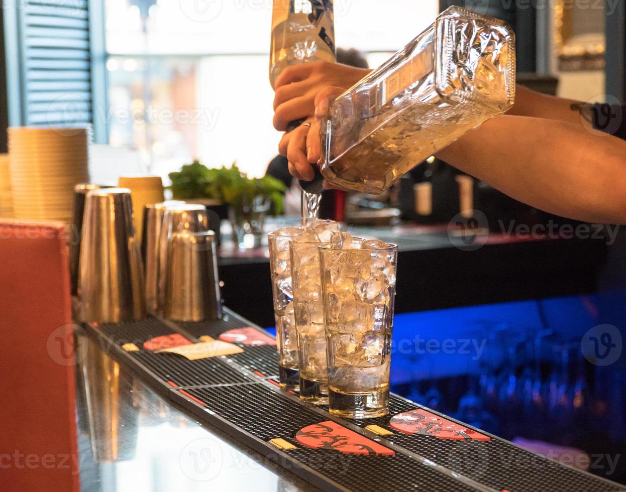 Barkeeper bereitet einen Cocktail mit Eis zu, Nahaufnahme foto