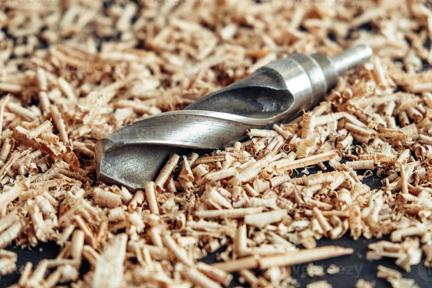 Holzbohrer mit Holzspänen auf schwarzem Hintergrund foto