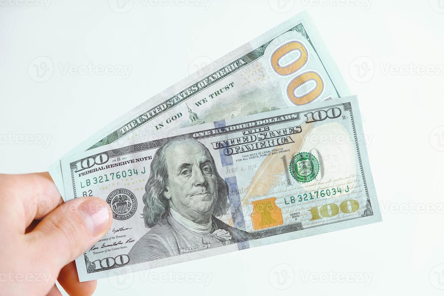 zweihundert-Dollar-Scheine in der Hand auf weißem Hintergrund foto