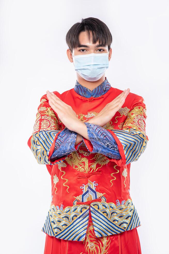 Mann trägt Cheongsam-Anzug und Maske zeigen, dass die Leute keine Maske tragen, kann im chinesischen Neujahr nicht zum Einkaufen kommen foto