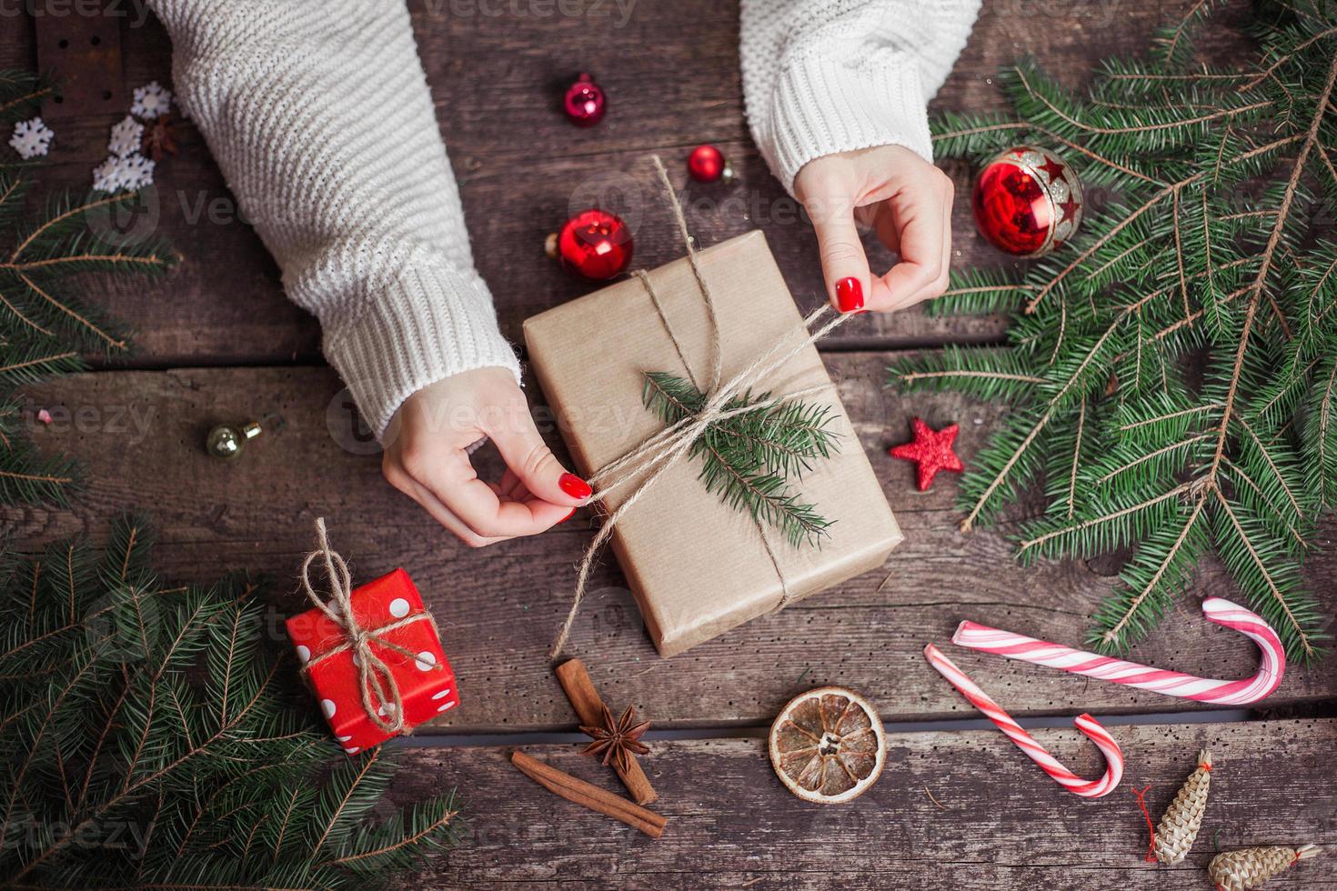 Frau hält eine Geschenkbox in einer Geste des Gebens. foto