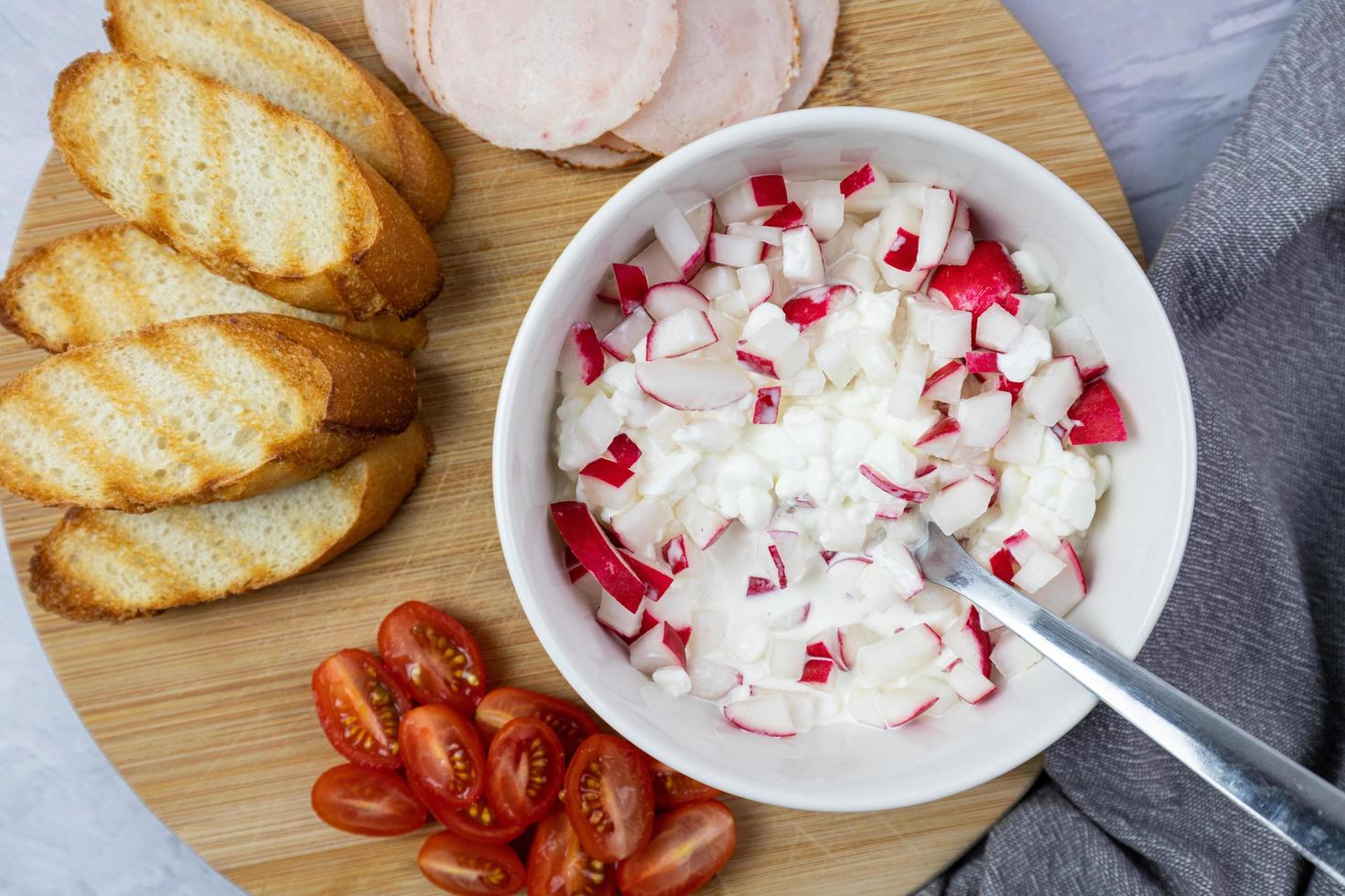 Hüttenkäse mit Rettich, Tomaten, Schinken und Brot. ein gesundes Frühstück. foto