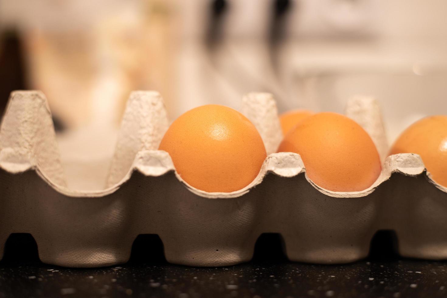 Eier in einem Eierkarton aus Pappe. Zubereitung der Zutaten zum Kochen. foto