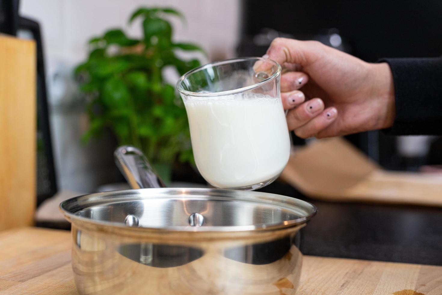 Milch in einen Topf gießen. Zubereitung von Bechamelsauce. foto