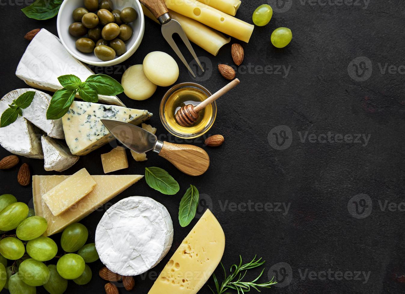 verschiedene Arten von Käse, Trauben, Honig und Snacks foto