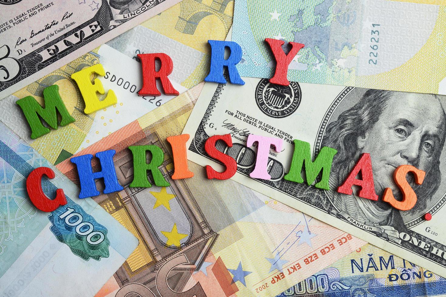 das Wort Frohe Weihnachten auf den Banknoten als Hintergrund. foto